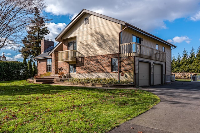 view of home's exterior with a lawn, a balcony, and a garage