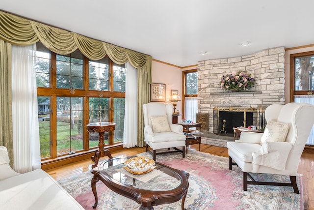 living room featuring hardwood / wood-style flooring, crown molding, and a fireplace