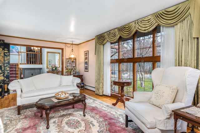 living room featuring wood-type flooring, ornamental molding, a notable chandelier, and a healthy amount of sunlight