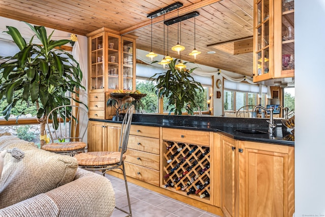 bar with light tile patterned floors, sink, pendant lighting, and wood ceiling