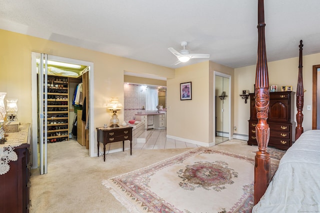 bedroom with a textured ceiling, light colored carpet, baseboard heating, and ceiling fan