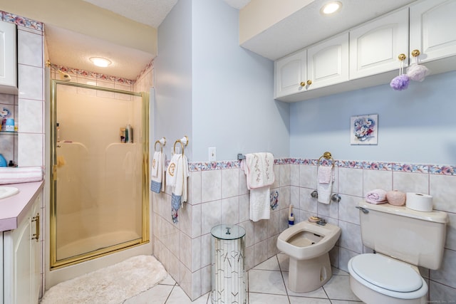 bathroom featuring walk in shower, a textured ceiling, toilet, vanity, and tile walls