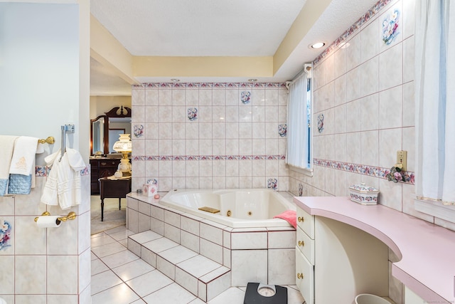 bathroom featuring vanity, a relaxing tiled tub, tile patterned floors, and tile walls