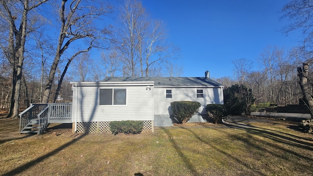 view of front of property with a wooden deck and a front lawn