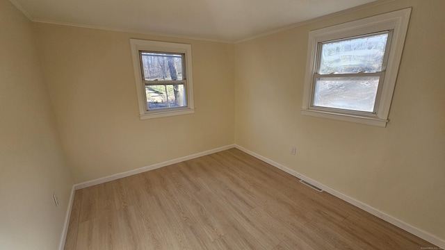 empty room featuring light hardwood / wood-style floors and crown molding