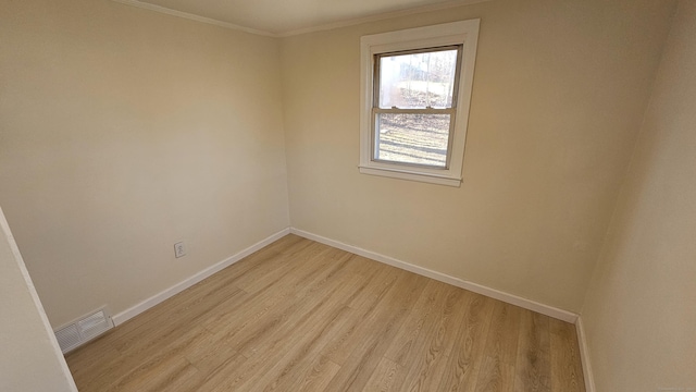 empty room featuring light hardwood / wood-style flooring and ornamental molding