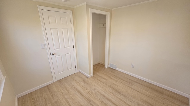 unfurnished bedroom featuring light wood-type flooring, a closet, and ornamental molding