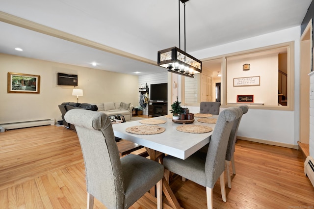 dining space with an AC wall unit, light hardwood / wood-style flooring, and a baseboard heating unit