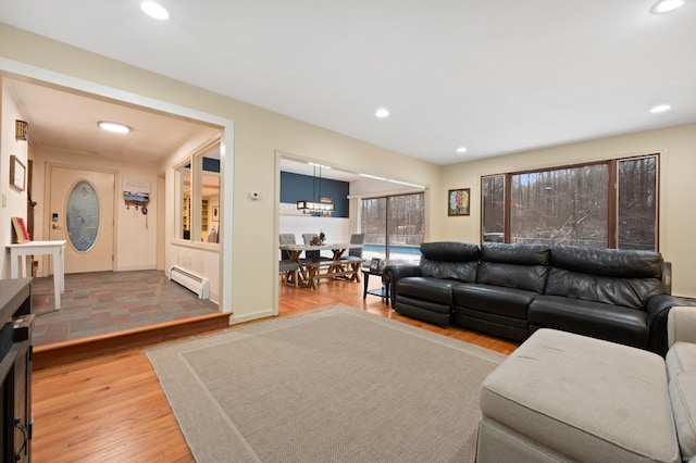 living room featuring wood-type flooring and a baseboard heating unit