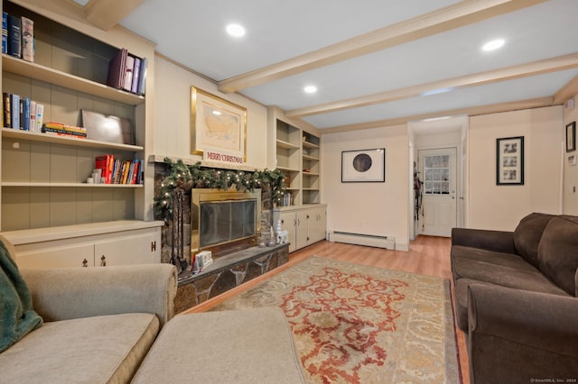 living room with beam ceiling, built in shelves, light hardwood / wood-style flooring, a baseboard heating unit, and a fireplace