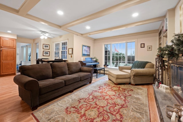 living room with beam ceiling, ceiling fan, a baseboard radiator, and light wood-type flooring