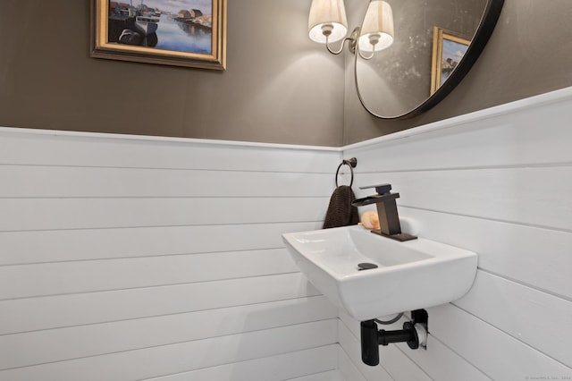 bathroom with wooden walls and sink