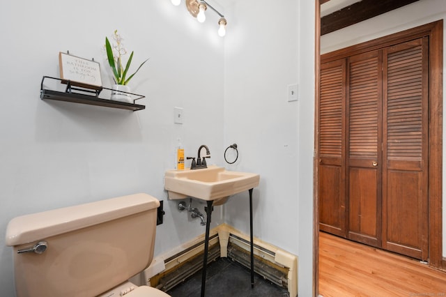 bathroom with toilet, a baseboard radiator, and hardwood / wood-style flooring