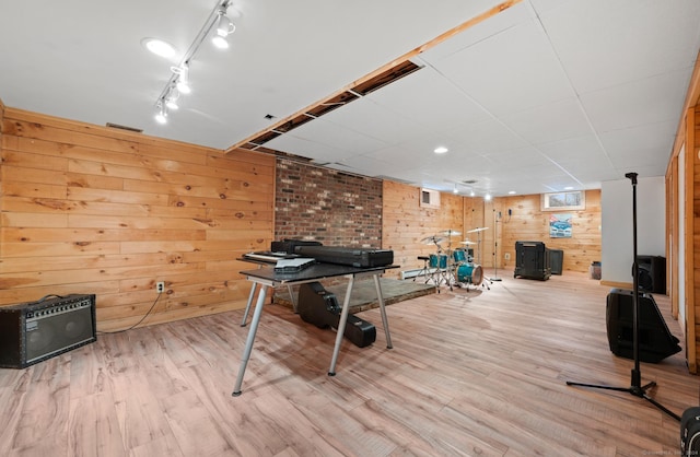 playroom featuring rail lighting, light hardwood / wood-style flooring, and wooden walls