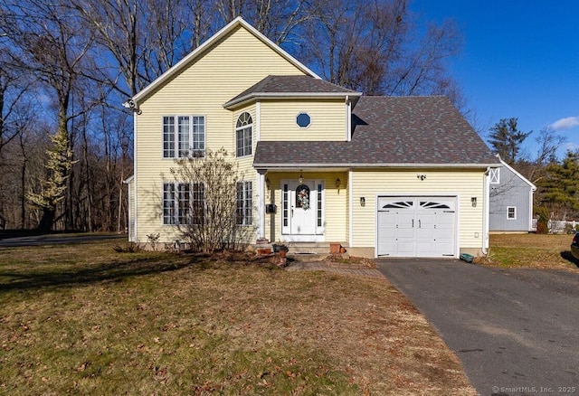 view of property with a garage and a front lawn