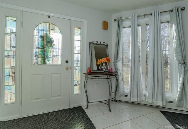 doorway with light tile patterned flooring and a wealth of natural light