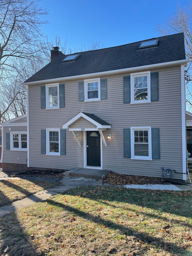 colonial-style house featuring a front lawn