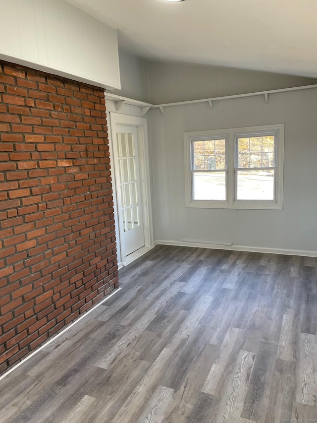 spare room with hardwood / wood-style flooring and lofted ceiling