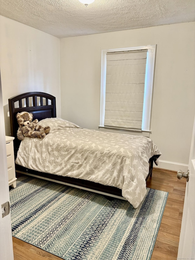 bedroom featuring hardwood / wood-style floors and a textured ceiling