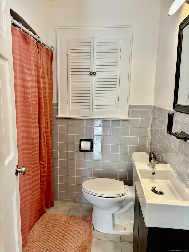 bathroom with a shower with curtain, vanity, tile walls, tile patterned flooring, and toilet