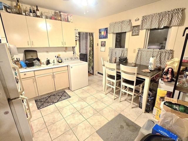 kitchen with ceiling fan, white refrigerator, washer / dryer, and light tile patterned floors