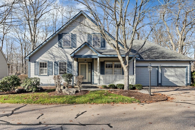 view of property with a porch and a garage