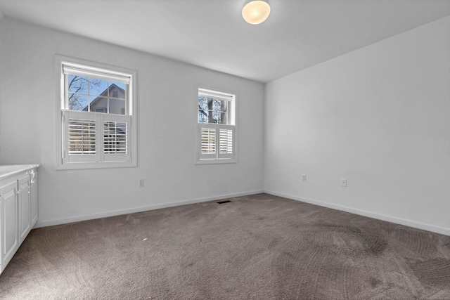 spare room featuring carpet and a healthy amount of sunlight