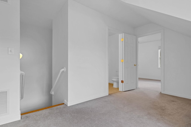 bonus room with lofted ceiling and light carpet