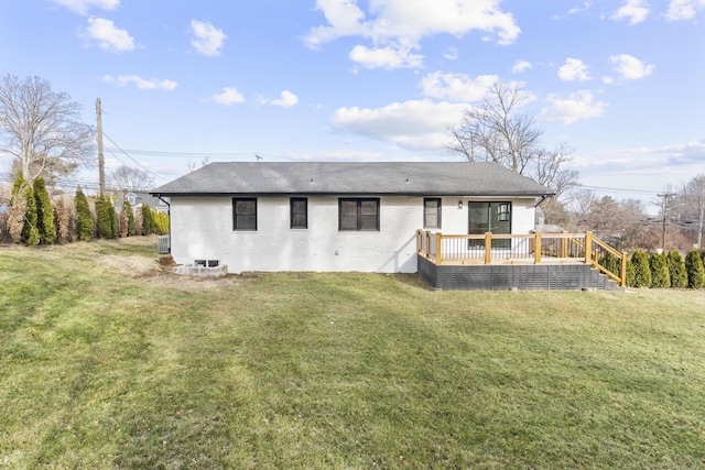 rear view of property featuring a yard and a deck