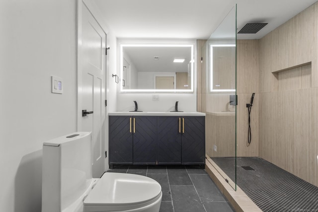 bathroom featuring toilet, tiled shower, tile patterned floors, and vanity