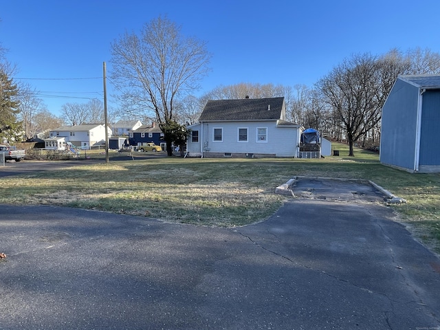 view of home's exterior featuring a lawn and a shed