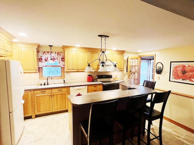 kitchen featuring a breakfast bar, white appliances, sink, pendant lighting, and a kitchen island