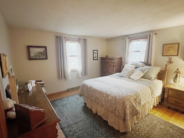 bedroom with a baseboard radiator and dark hardwood / wood-style floors