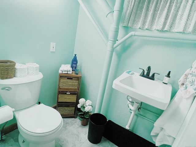 bathroom featuring tile patterned flooring, toilet, and sink