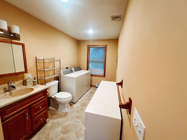 bathroom with washer and dryer, vanity, and toilet