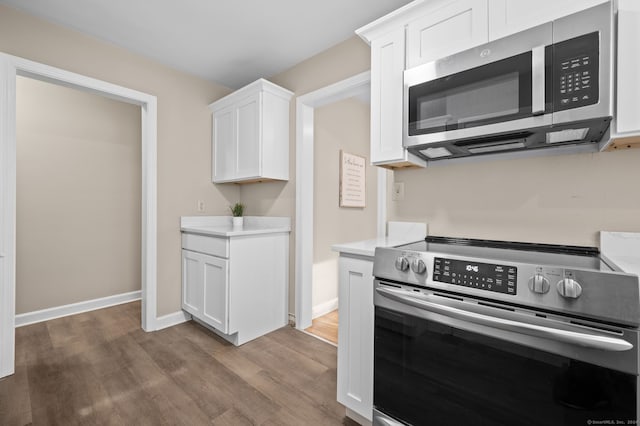 kitchen with white cabinetry, stainless steel appliances, and dark hardwood / wood-style floors