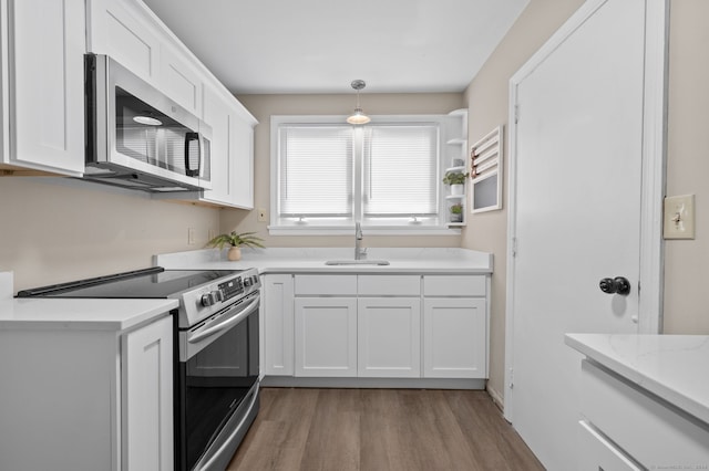 kitchen featuring white cabinets, light hardwood / wood-style floors, sink, and stainless steel appliances