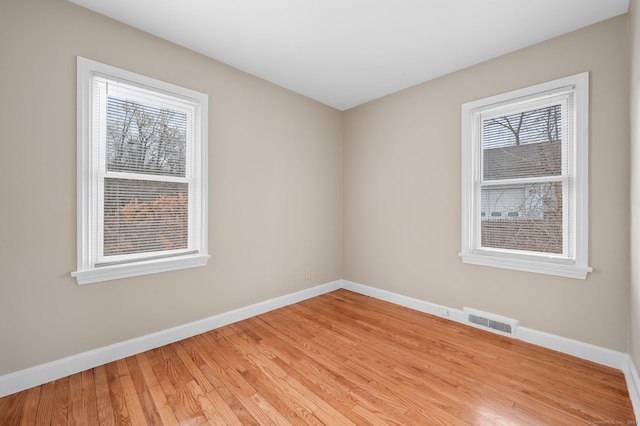 spare room with a healthy amount of sunlight and light hardwood / wood-style flooring