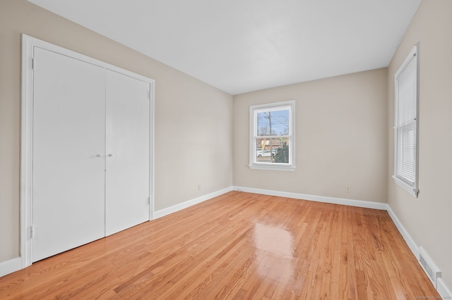 unfurnished bedroom featuring light wood-type flooring and a closet