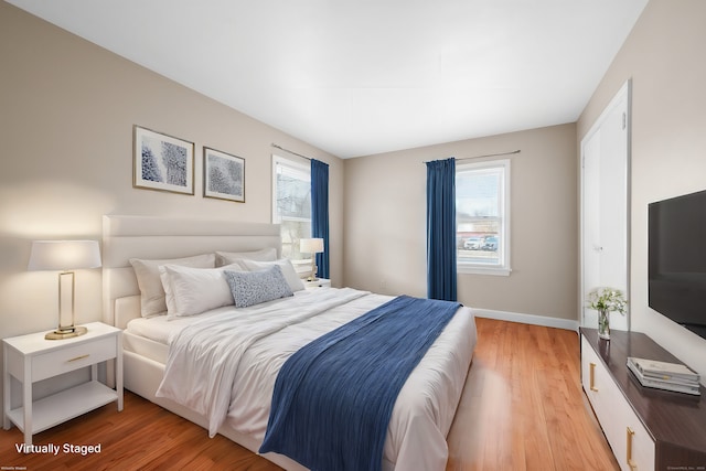 bedroom featuring light hardwood / wood-style floors and multiple windows