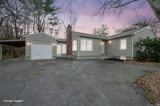 ranch-style home featuring a garage and a carport