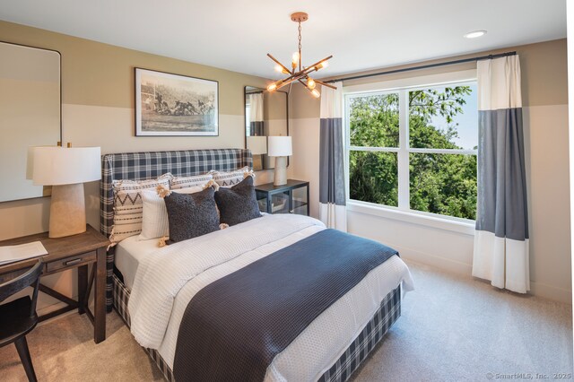 bedroom featuring an inviting chandelier, baseboards, and carpet flooring