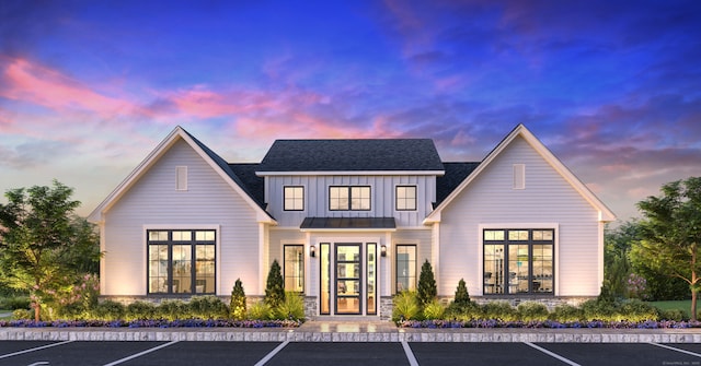 view of front of home with board and batten siding, uncovered parking, and a shingled roof