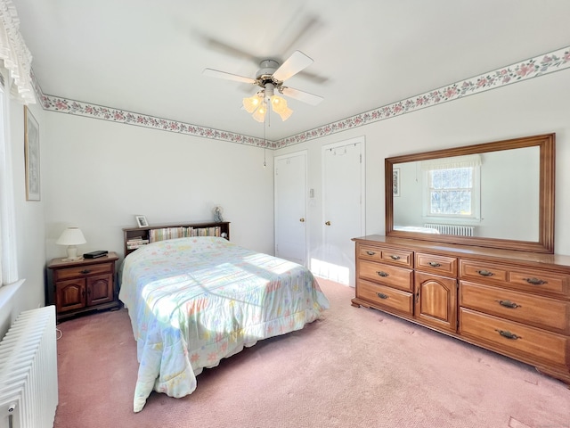 bedroom with light carpet, radiator heating unit, and ceiling fan