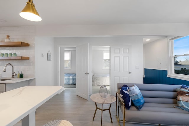 living room with light hardwood / wood-style floors, a healthy amount of sunlight, and sink