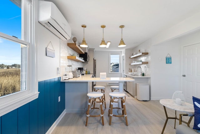 kitchen with decorative backsplash, kitchen peninsula, a breakfast bar, light hardwood / wood-style flooring, and an AC wall unit