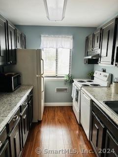 kitchen featuring light stone counters, dark hardwood / wood-style flooring, and white electric stove