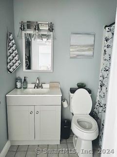 bathroom featuring tile patterned flooring, vanity, and toilet