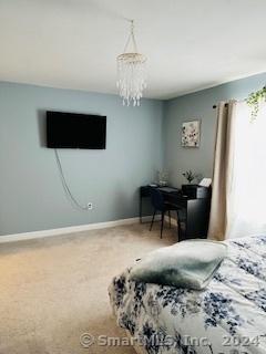 carpeted bedroom with a chandelier