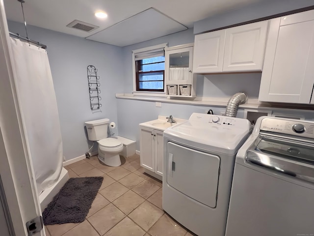 laundry area with sink, light tile patterned floors, and washing machine and clothes dryer